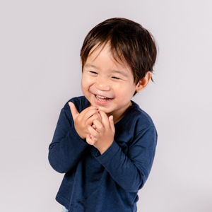 Toddler boy laughing, white background