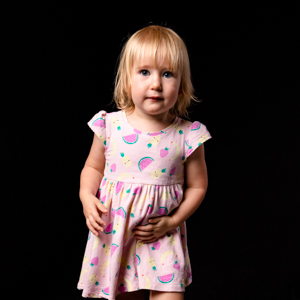 Toddler girl standing with black background